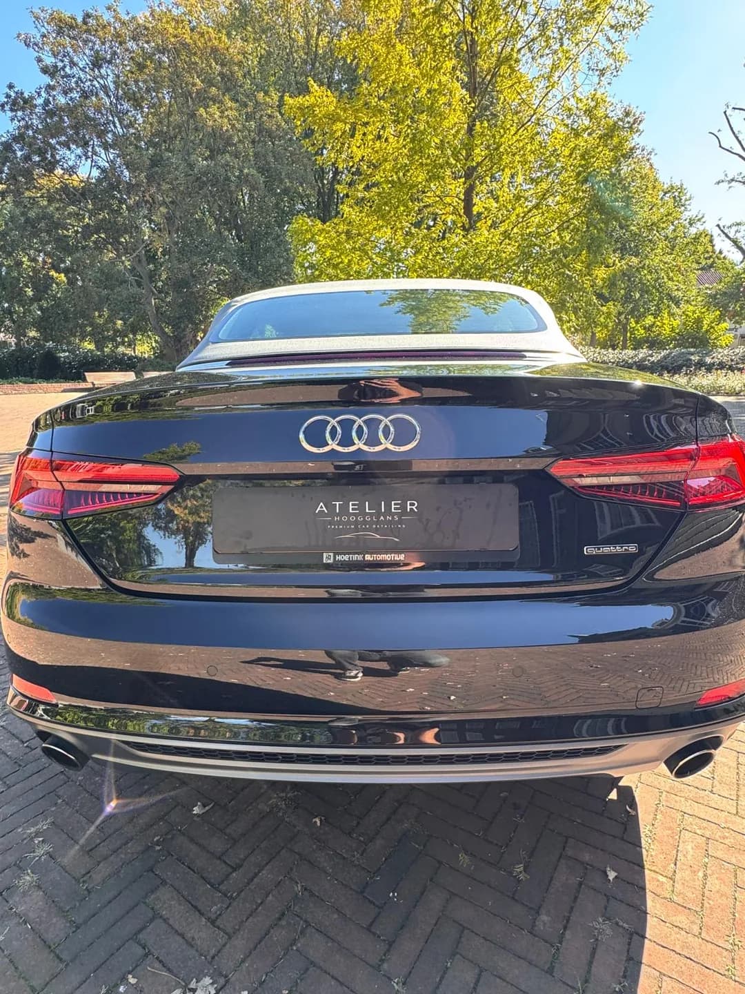 Achterzijde van de Audi cabriolet met reflecties en Atelier Hoogglans kentekenafdekking