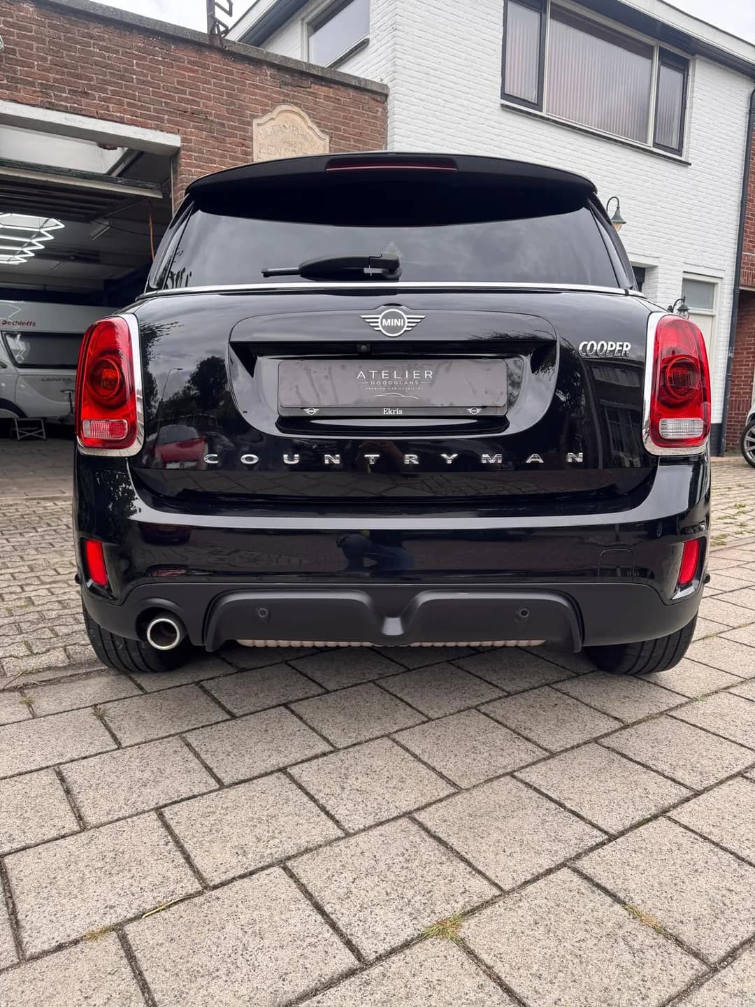Achterzijde van de zwarte MINI Countryman met Atelier Hoogglans kentekenafdekking